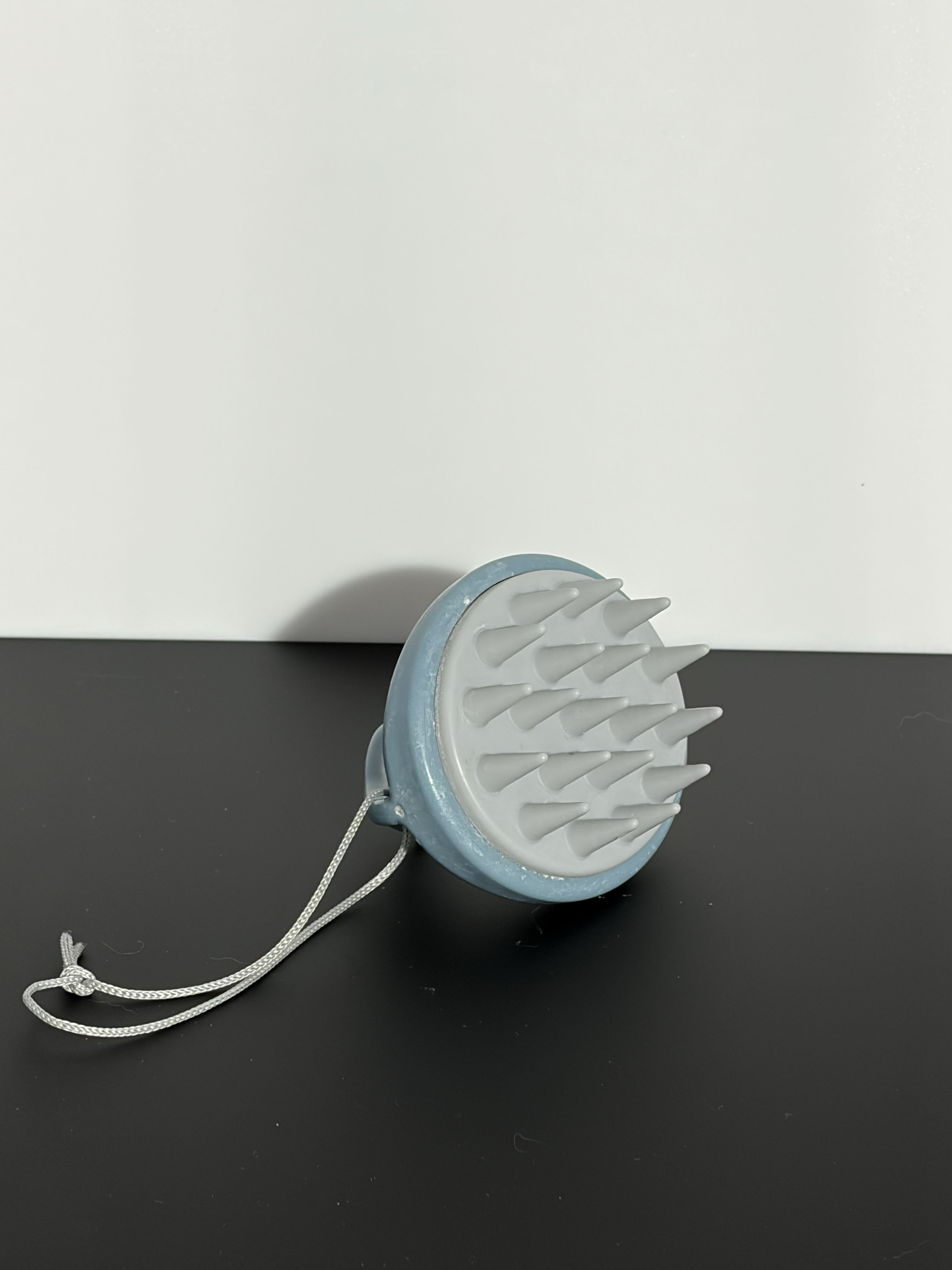 The three-quarter view of the bottom of a hair shampoo tool