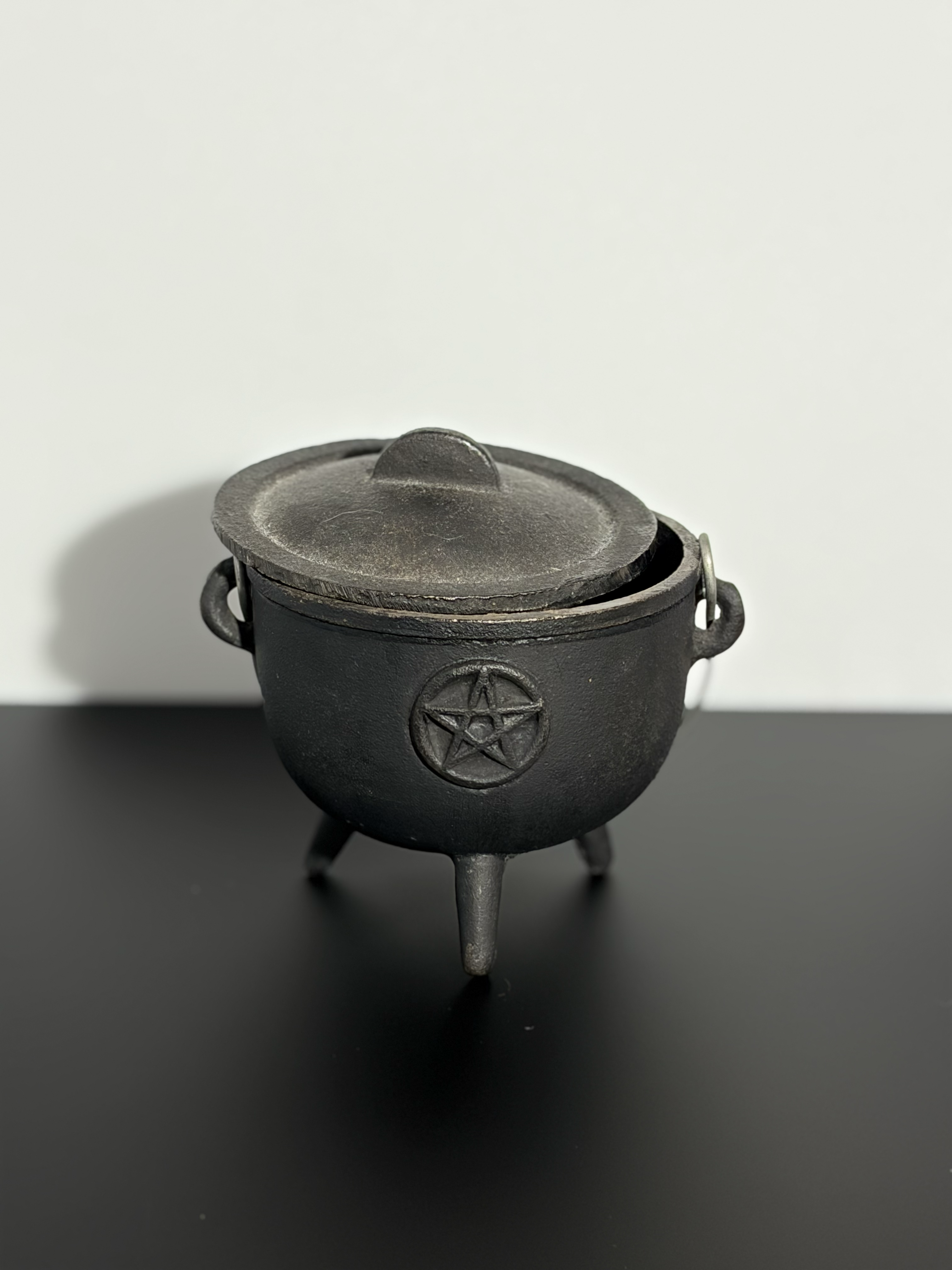 Front view of a cauldron with the lid to the side.