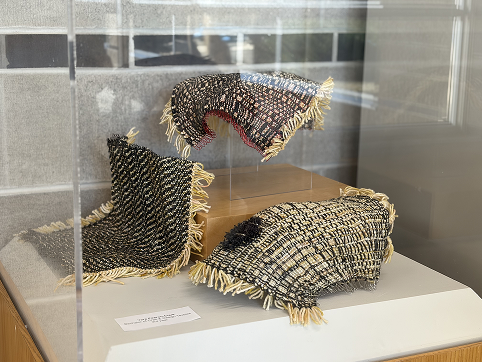 A peice woven together with textile materials: yarn and thread (as well as wire in order to create the curved shape). Done by the Textiles, Honors Bachelor of Craft and Design  program.<div class='container'><iframe class='responsive-iframe' src='https://www.youtube.com/embed/tgbNymZ7vqY'></iframe></div>
